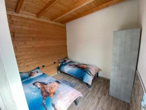 a bedroom with two beds and a wooden ceiling at Agriturismo La Falesia in Bagnasco