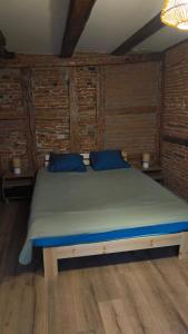 a bedroom with a large bed with blue pillows at Logis Saint Martin in Colmar