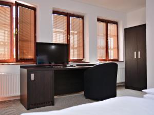 ein Büro mit einem Schreibtisch mit einem Monitor und einem Stuhl in der Unterkunft Hotel Atrium in Pardubice