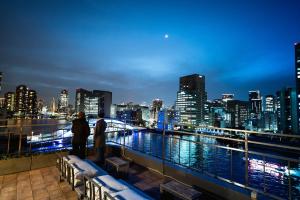 two people standing on a balcony looking at a city skyline at ulu Tokyo in Tokyo
