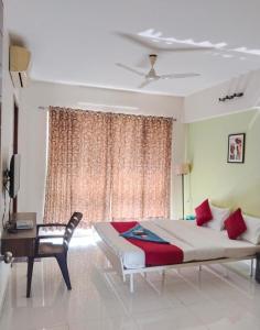 a bedroom with a bed and a desk and a window at GM Hospitality Services pune in Pune +9 photos