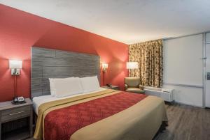 a hotel room with a bed and a chair at Econo Lodge Thomasville in Thomasville +22 photos