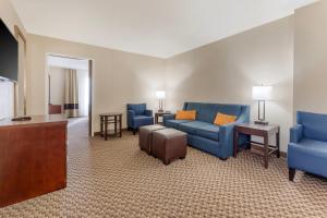 a living room with blue furniture and a flat screen tv at Comfort Inn Ebensburg in Ebensburg