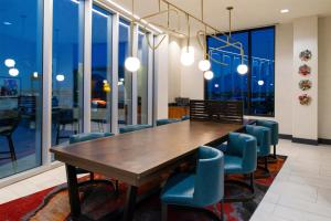 a dining room with a wooden table and blue chairs at Hyatt Place Chicago Wicker Park in Chicago
