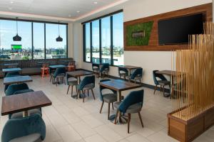 a restaurant with tables and chairs and a flat screen tv at Hyatt Place Chicago Wicker Park in Chicago