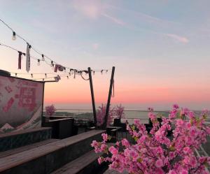 a view of the sunset from a restaurant with pink flowers at STORY HOTEL MALMO, in JdV by Hyatt in Malmö