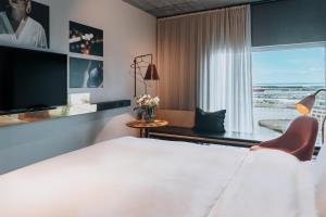 a hotel room with a bed and a large window at STORY HOTEL MALMO, in JdV by Hyatt in Malmö