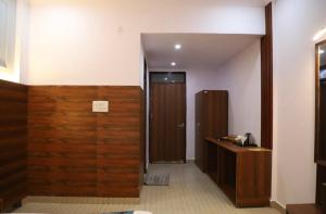 a bathroom with a wooden door and a wooden cabinet at Hotel Black Stone Palace in Ghaziabad +6 photos