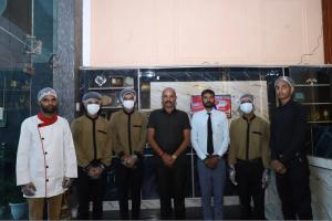 a group of men wearing masks standing in a room at Hotel Black Stone Palace in Ghaziabad