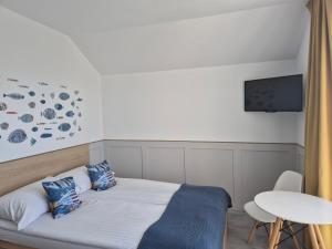 a bedroom with a bed and a table and a tv at Willa Kardamon in Władysławowo