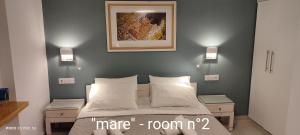 a bedroom with a bed with two night stands and two lamps at Papadioti Apartments in Pefki