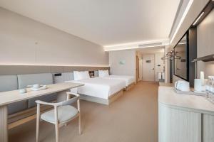 a large hotel room with a bed and a kitchen at Zhangjiajie JI Hotel- New hotel, Free pick up service, Free shuttle service for Tianmen Mount Cableway, Smart Hotel&Root Service,King Koil mattress, Free self-service laundry,Toursim Service&English Customer Service in Zhangjiajie
