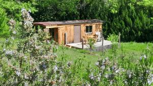 a small wooden shack in a field of flowers at Roulotte pour amoureux de la nature in Bugarach