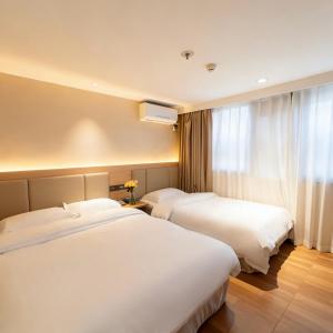 a hotel room with two beds and a window at Shenzhen Green Oasis Hotel, Baoan in Bao'an