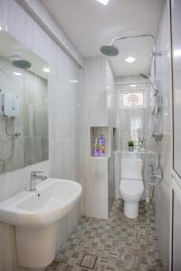 a white bathroom with a sink and a toilet at Eastern Apartment in Jelutong +25 photos
