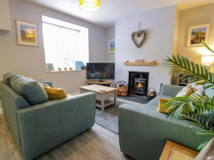 a living room with two couches and a fireplace at Y Bwthyn in Llanbedr