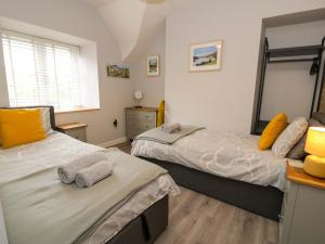 a bedroom with two beds and a mirror at Y Bwthyn in Llanbedr
