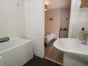 a bathroom with a white tub and a sink at Y Bwthyn in Llanbedr +34 photos