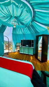 a bedroom with a red bed with a blue ceiling at The Mountain Vault in Barog