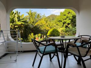 a table and chairs in a room with a window at Paul's Residence in Mahe