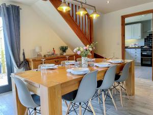 a dining room with a wooden table and chairs at Redroofs Barn - 28184 in Weston