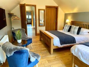 a hotel room with a bed and two chairs at Redroofs Barn - 28184 in Weston