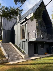 a house with a balcony and stairs in front of it at Spa Villa Smetovi with Jacuzzi & Sauna in Zenica
