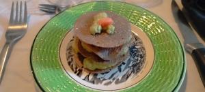 a green plate with food on a table at Chambres d'hôtes Las Carbounieros in Auriac