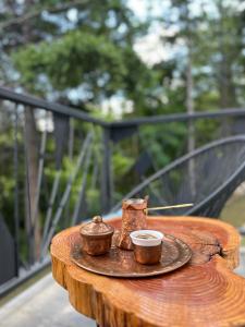 a wooden table with two cups and a bowl on it at Spa Villa Smetovi with Jacuzzi & Sauna in Zenica