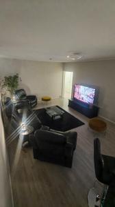 a living room with a couch and a flat screen tv at SEA - 3 Bedrooms in Kristinestad