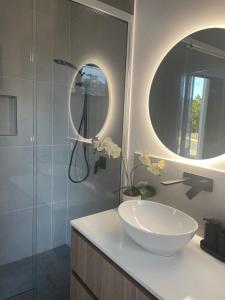 a bathroom with a sink and a mirror at Eden on Beach in Palm Cove +1 photo