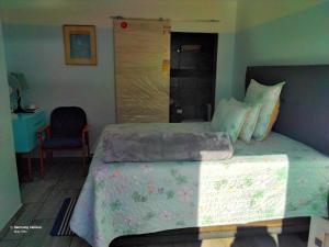 a bedroom with a large bed and a chair at Dante Guest house in Alberton +35 photos