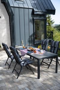 a picnic table with chairs on a patio at Spa Villa Smetovi with Jacuzzi & Sauna in Zenica