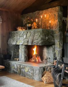a stone fireplace with a fire in it at Cabin With Rauland Mountain Views in Rauland +19 photos