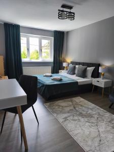 a bedroom with a bed and a desk and window at Lyra Apartment 2 in Sfântu-Gheorghe