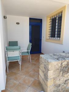 a room with two chairs and a table and a blue door at Diakofti Loft - Sea Breeze in Kythira