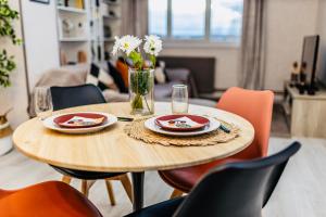 a wooden table with plates and flowers on it at Superbe appartement centre Montluçon, proche hôpital in Montluçon +10 photos