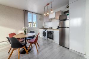 a kitchen with a table and chairs and a refrigerator at Superbe appartement centre Montluçon, proche hôpital in Montluçon