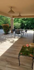 a patio with a table and chairs and trees at Chez Christine in Callian