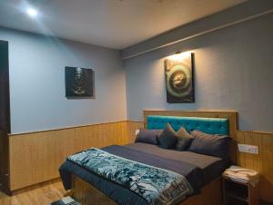 a bedroom with a bed and two pictures on the wall at Pratham Place in Kasol