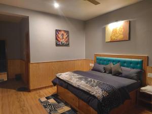 a bedroom with a bed with a blue headboard at Pratham Place in Kasol +7 photos
