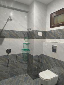 a bathroom with a toilet and a shower at Pratham Place in Kasol