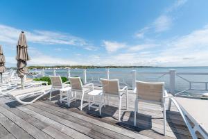 a group of chairs and umbrellas on a deck at Hampton Bays Townhouse - Pool Beach Access in Hampton Bays