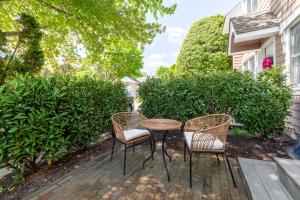 a patio with three chairs and a table and a table and chairs at Hampton Bays Townhouse - Pool Beach Access in Hampton Bays