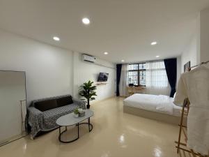 a bedroom with a bed and a couch and a table at S hostel 302 sukhumvit48 near Phrakanong BTS in Amphoe Phra Khanong