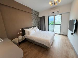 a hotel room with a bed and a large window at Go Chishang B&B in Chishang