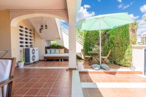 a patio with an umbrella and a table and chairs at Can Tomeu in Calas de Mallorca
