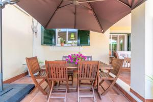 a table and chairs with an umbrella on a patio at Can Tomeu in Calas de Mallorca
