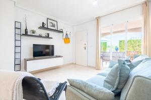 a living room with a couch and a tv at Can Tomeu in Calas de Mallorca