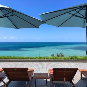 a view of the ocean from a deck with two chairs and an umbrella at Mandrati Loft in Sarpi